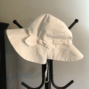 HAT. 0-12 MONTHS.  WHITE COTTON.  CAP IS LINED WITH 100% COTTON